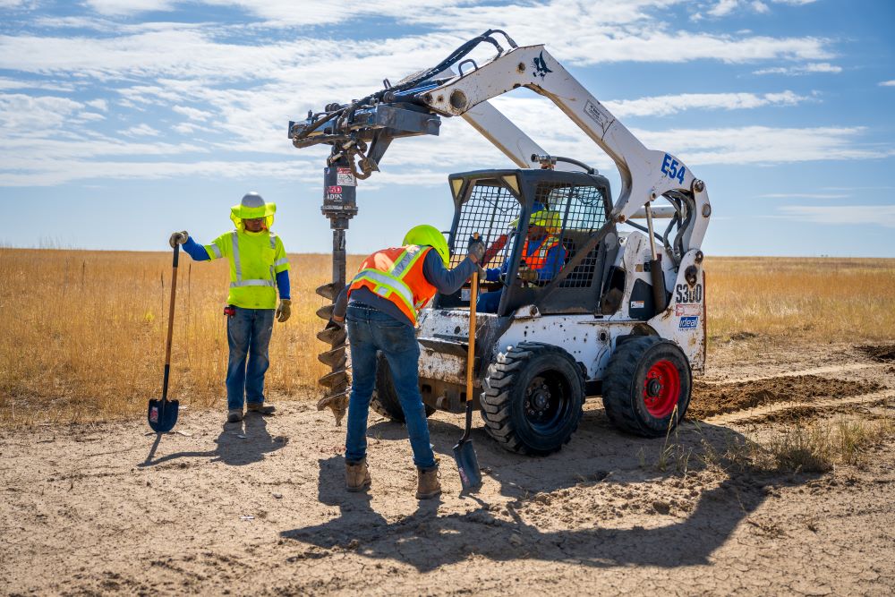 Ideal Fencing Corp crew operating equipment on a field installation